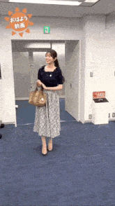 a woman in a floral skirt is standing in front of an aed machine