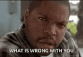 ice cube is making a funny face with the words `` what is wrong with you '' behind him .