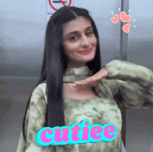 a woman in a green tie dye shirt with the word cutie written on it