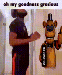 a man with a beard is standing next to a teddy bear holding a censored sign