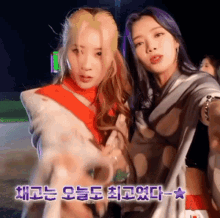 a couple of women standing next to each other with korean writing on the bottom