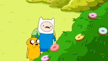 a group of cartoon characters are standing in a grassy area with donuts on the ground