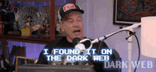 a man is sitting in front of a microphone with the words `` i found it on the dark web '' written on the screen .