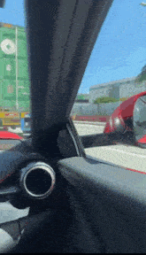 a red car is driving down a highway with a green container in the background