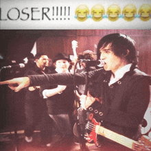 a man singing into a microphone while holding a guitar in front of a banner that says loser