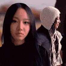 a woman with long black hair and a white hat