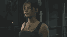 a woman is standing in a dark room wearing a black tank top and a necklace .