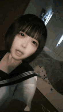 a girl with short black hair is taking a selfie