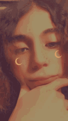 a close up of a woman 's face with crescent moons on her face