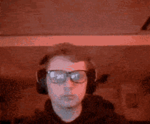 a man wearing headphones and glasses is looking at the camera