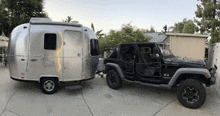 a silver airstream trailer is pulling a jeep wrangler