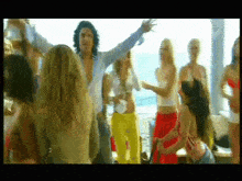 a group of women are dancing with a man standing in the middle
