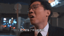 a man wearing glasses and a white shirt has chinese writing on his face