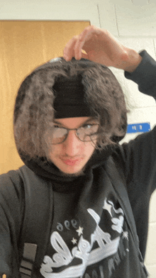a person wearing a headband and a hoodie with a crown on the front of it