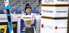 a person wearing a wurth shirt holds a ski