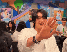 a man with a ring on his finger smiles in front of a group of people