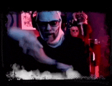 a blurry picture of a man standing in a dark room with a devil behind him .
