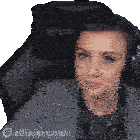 a woman wearing headphones is sitting in a chair with the words elliejoypanic on the bottom