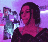 a woman wearing headphones is standing in front of a purple wall with pictures on it