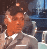 a woman in a suit and tie is looking at the camera