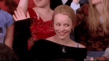 a woman is smiling in a crowd of people .