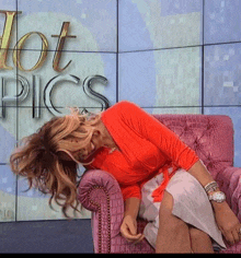 a woman sitting in a pink chair with the words hot pics behind her