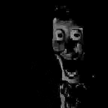 a black and white photo of a man 's face in a dark room .