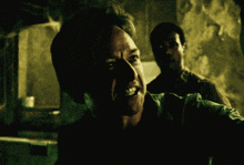 a man in a dark room is smiling and looking at the camera