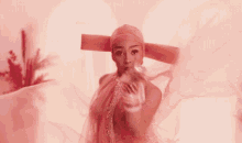 a woman in a pink dress with a huge hat on her head