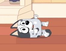 a cartoon dog laying on its back on a wooden floor