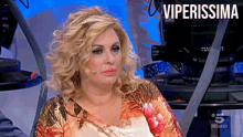 a woman sitting in front of a camera with the words viperissima on the bottom right