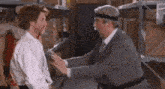 two men are standing next to each other in a warehouse . one of the men is wearing a headband .