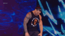 a wrestler is standing in front of a crowd at a raw live event