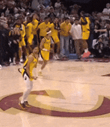 a group of basketball players are standing on a court with the letter g on it