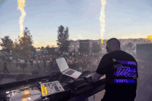 a man wearing a shirt that says " vinyl " is playing music