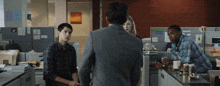 a man in a suit stands in front of a cubicle with a sign that says ' e-mail '