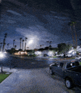 a truck is parked on the side of the road in a residential area at night