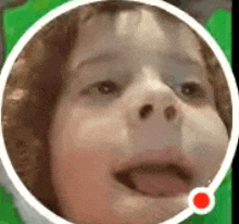 a close up of a child 's face with his tongue out in a white circle .
