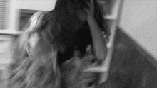 a blurry black and white photo of a woman standing on stairs .