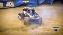 a monster jam truck is driving down a dirt road