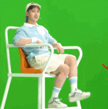 a man is sitting in a chair with a cigarette in his mouth .