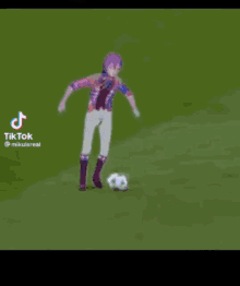 a soccer player is kicking a soccer ball while another player watches .