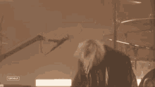 a man in a leather jacket is singing into a microphone while playing a guitar