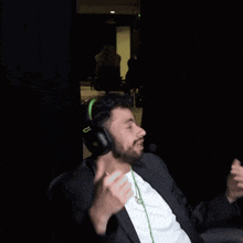 a man wearing headphones and a necklace with the letter g on it is dancing