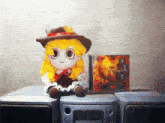 a stuffed doll sits on a stereo next to a cd case
