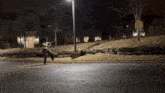 a person walking down a street at night with a sign that says no parking