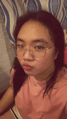 a girl wearing glasses and a pink shirt