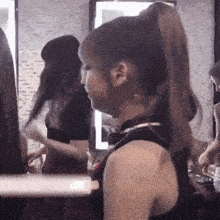 a woman with a ponytail stands in front of a mirror in a room