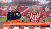 two men in red and white striped shirts are sitting in front of a red and white striped stadium