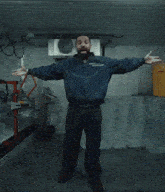 a man in a blue jacket is standing in a room with a yellow bucket